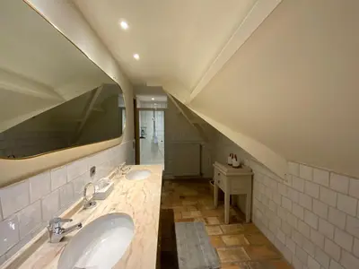 a bathroom with two sinks and a large mirror at B&B de Graaf van Poppel in Poppel