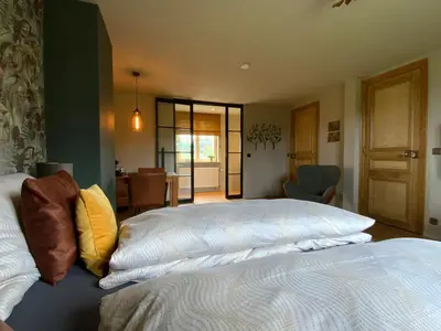 a bedroom with a bed with white sheets and yellow pillows at B&B de Graaf van Poppel in Poppel