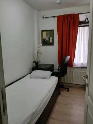 a bedroom with a bed and a desk and a chair at Kamertje in Asse