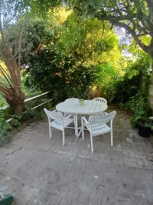 a white table and two chairs on a patio at Kamertje in Asse