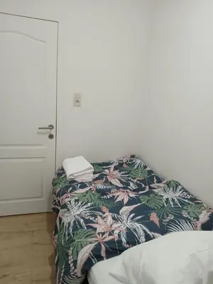 a room with a bed with a blanket and a door at Kamertje in Asse