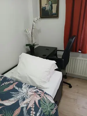 a bedroom with a desk and a bed and a chair at Kamertje in Asse