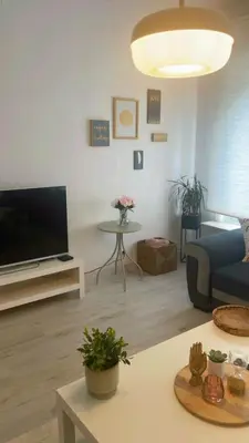 a living room with a blue couch and a tv at Apartment near atomium with parking in Vilvoorde