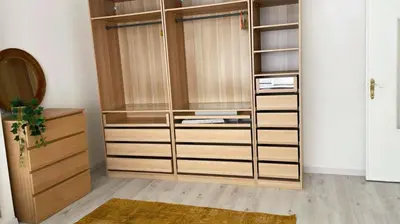 a closet with wooden and glass cabinets and a rug at Apartment near atomium with parking in Vilvoorde