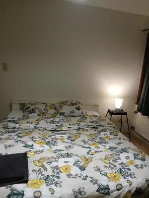 a bed with a floral comforter in a bedroom at Dorpje in Asse