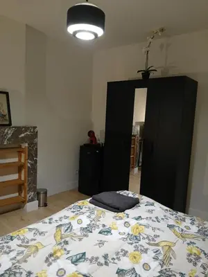a bedroom with a bed and a black cabinet at Dorpje in Asse