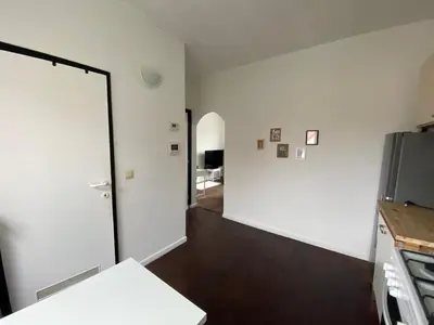 a kitchen with a white wall and a door at Trendy studio at top location in Antwerp