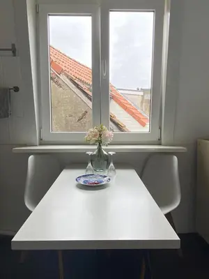a vase with flowers on a table in front of a window at Trendy studio at top location in Antwerp