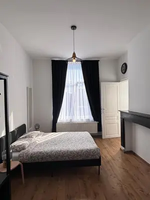 a bedroom with a bed and a large window at Studio Nahida in Brussels