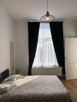 a bedroom with a bed and a large window at Studio Nahida in Brussels