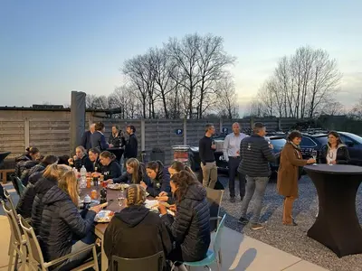 a group of people sitting at tables in a yard at Vakantiewoning De Poort in Zottegem