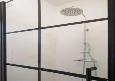 a shower with a glass door with a shower head at Top Location - City Center 1BR with Stylish Decor in Antwerp