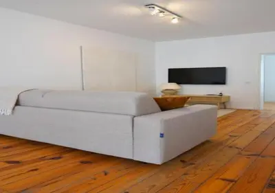 a living room with a white couch and a television at Top Location - City Center 1BR with Stylish Decor in Antwerp