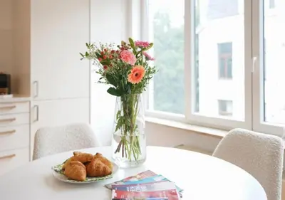 a vase with flowers and a plate of pastries on a table at Top Location - City Center 1BR with Stylish Decor in Antwerp