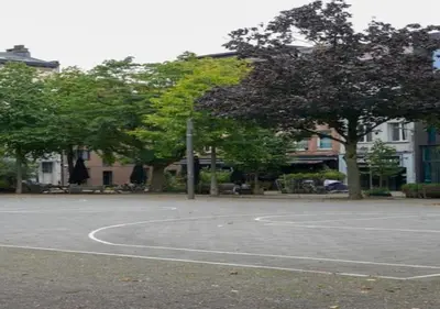 an empty basketball court with trees and buildings at Hip & Historic Stay Antwerp in Antwerp