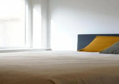 a bed with a yellow pillow and a window at Hip & Historic Stay Antwerp in Antwerp