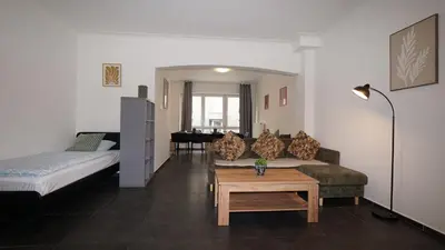 a room with a bed and a couch and a table at Consci apartments in Antwerp