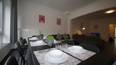 a dining room with a table and chairs and a couch at Consci apartments in Antwerp