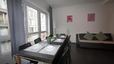 a dining room with a table and chairs and a couch at Consci apartments in Antwerp