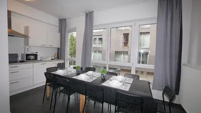 a kitchen with a table with chairs and a large window at Consci apartments in Antwerp