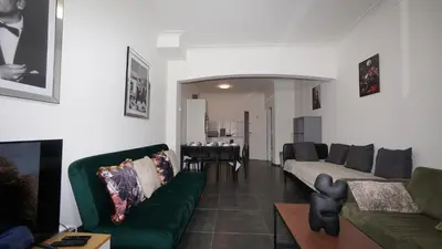 a living room with two green couches and a table at Consci apartments in Antwerp