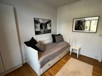 a small bed in a room with two pictures on the wall at B&B Den Engel in Kortenberg