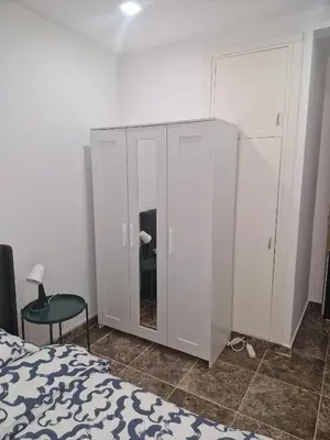 a bedroom with a white cabinet and a bed at Luxe Bruxelles in Brussels