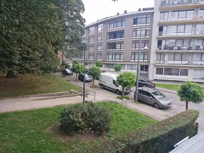 a large building with cars parked in a parking lot at Luxe Bruxelles in Brussels