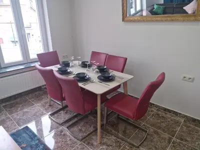a dining room table with red chairs and a mirror at Luxe Bruxelles in Brussels