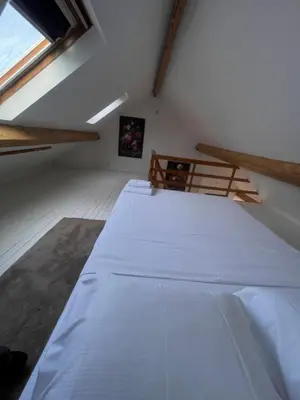 a large white bed in a room with a window at Attic European Quarter in Brussels