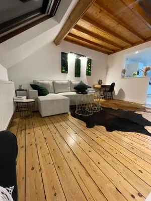 a living room with a couch and a wooden floor at Attic European Quarter in Brussels