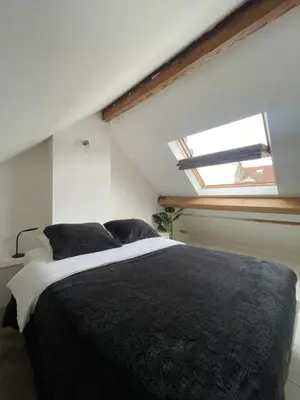 a bedroom with a black and white bed with a window at Attic European Quarter in Brussels
