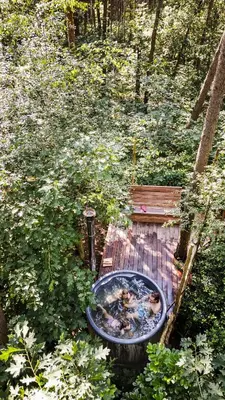 a hot tub on a wooden deck in the woods at Bosuil in Retie