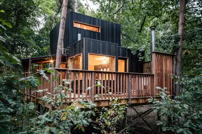 a house in the woods with a wooden deck at Bosuil in Retie