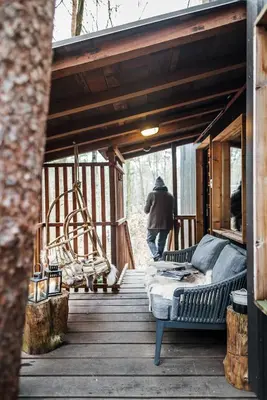 a person walking on a porch with a bed on a deck at Bosuil in Retie