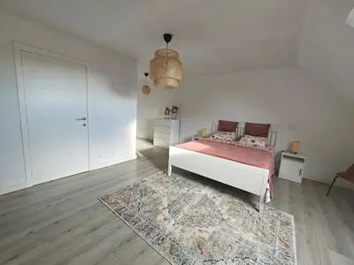 a white bedroom with a bed and a rug at Casa Rosa Leuven in Herent