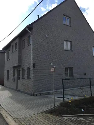 a large brick building with a fence in front of it at Casa Rosa Leuven in Herent