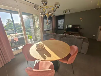 a living room with a table and chairs and a couch at Casa Rosa Leuven in Herent