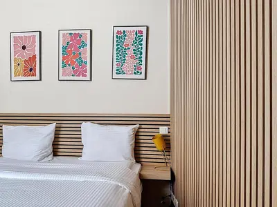 a hotel room with a bed and three pictures on the wall at Slina Hotel Brussels in Brussels