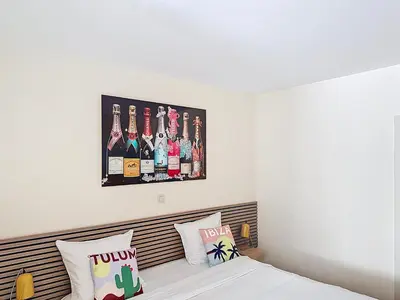 a bedroom with a bed with a picture of bottles on the wall at Slina Hotel Brussels in Brussels