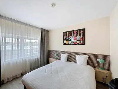 a bedroom with a white bed and a large window at Slina Hotel Brussels in Brussels