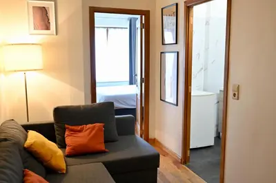 a living room with a couch and a bedroom at Brussels Midi Apartment in Brussels