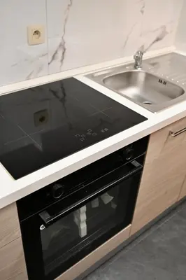 a kitchen with a sink and a black oven at Brussels Midi Apartment in Brussels