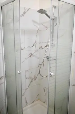 a bathroom with a shower with a glass door at Brussels Midi Apartment in Brussels