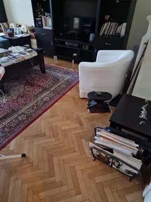 a living room with a hard wood floor and a table at La ferme rose in Brussels
