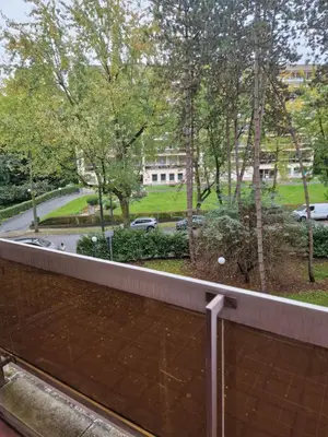 a balcony with a view of a street and trees at La ferme rose in Brussels