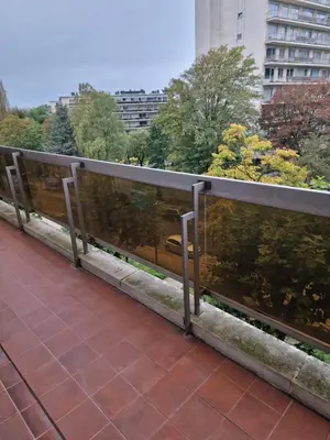a metal railing on a walkway in a city at La ferme rose in Brussels