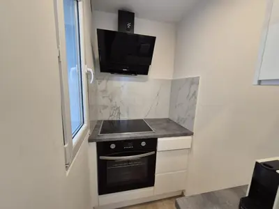 a kitchen with a stove and a tv on the wall at Tasson Snel apartment center of Brussels in Brussels