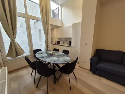 a living room with a table and chairs and a couch at Tasson Snel apartment center of Brussels in Brussels