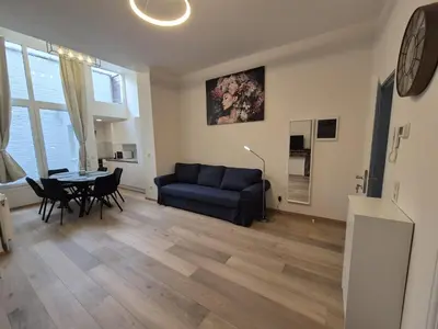 a living room with a blue couch and a table at Tasson Snel apartment center of Brussels in Brussels